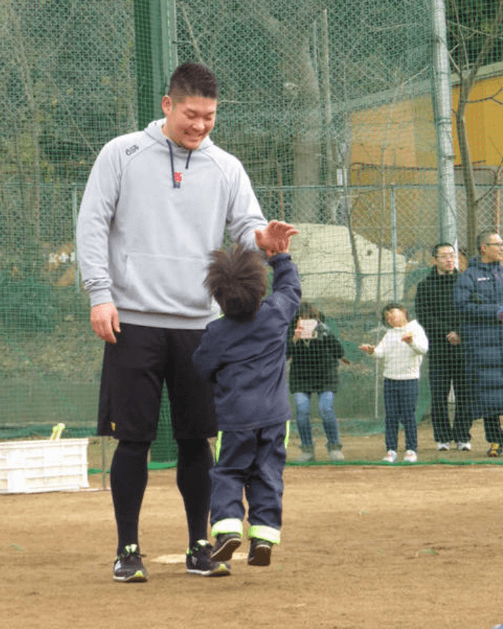 野球体験会で参加した子供とタッチする筒香嘉智選手の画像